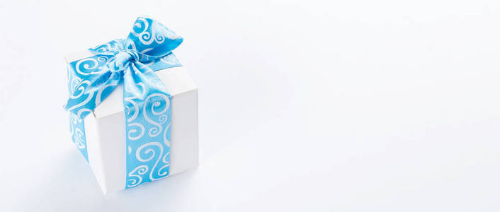 单一的地方礼品盒与浅蓝色丝带在白色的桌子上。卡。复制空间