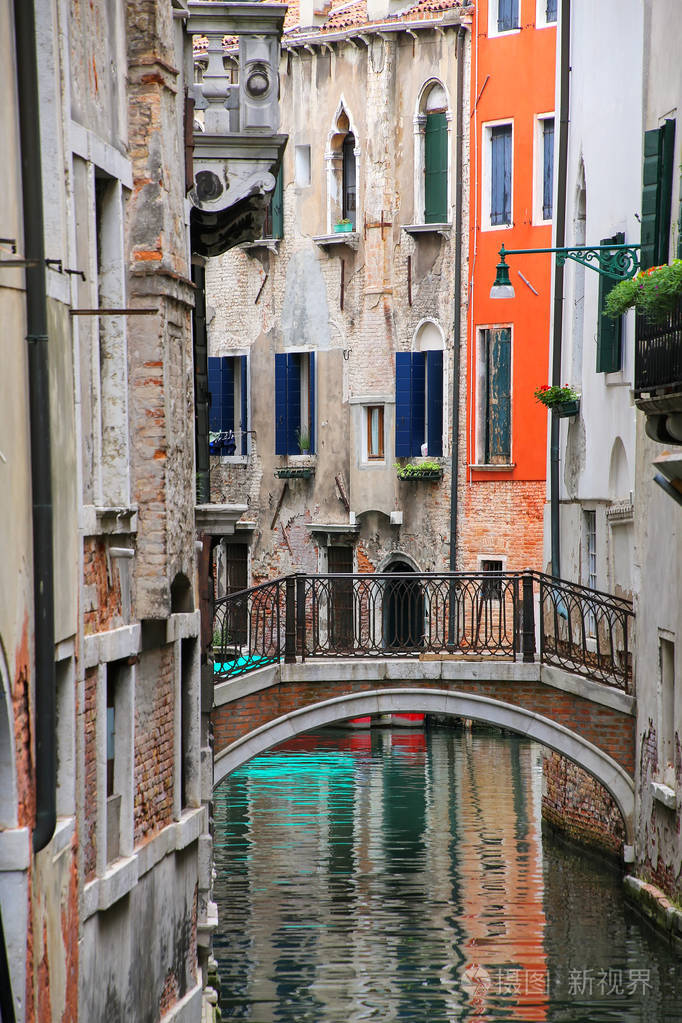 沿着狭窄的运河连接由一座石桥在威尼斯的房子