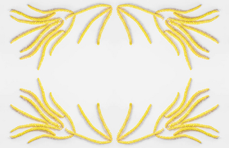 抽象花卉组成的花黄色雏菊耳环在灰色的背景与文本的空间框架。平躺，顶视图