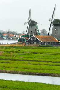 传统的荷兰风车和河岸上的老农场房子