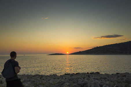 人类站在克罗地亚的亚得里亚海附近日落