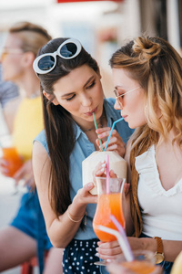 美丽的年轻女友一起喝夏日鸡尾酒在海滩酒吧