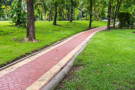 绿色公共公园的红砖走道照片