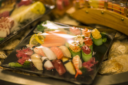 寿司和生鱼片在市场上滚动。新鲜的寿司配鲑鱼, 大虾, 芥末和姜。传统日本料理
