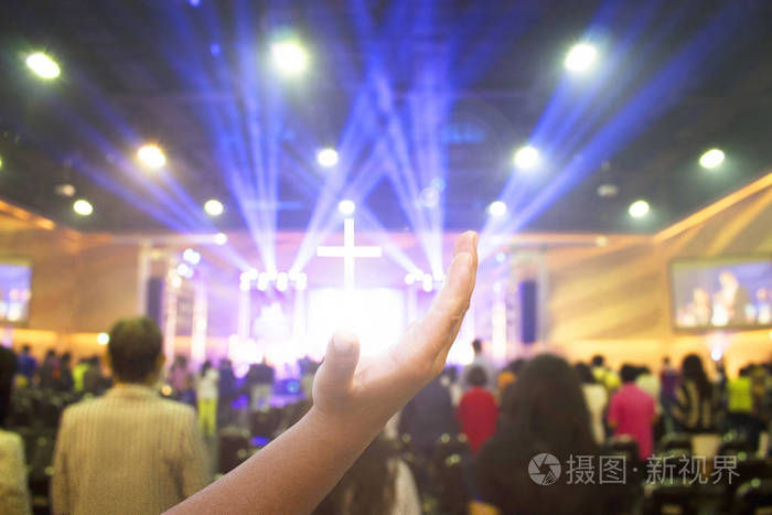 基督教人团体的软焦点举起手敬拜上帝耶稣基督在教会复兴会议上与木