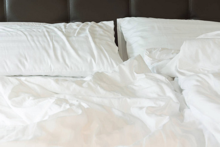 白色的枕头，在床上和皱凌乱条毯子，在卧室里，在一个漫长的夜晚睡不着觉