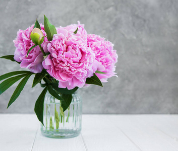 白色木桌上的粉红色牡丹花花瓶图片