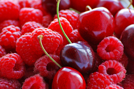 成熟的红莓和樱桃的浆果倒入一大堆照片