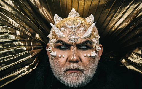 金色的金属背景, 梦幻的概念, 在脸上闪耀的龙皮肤和荆棘怪兽照片