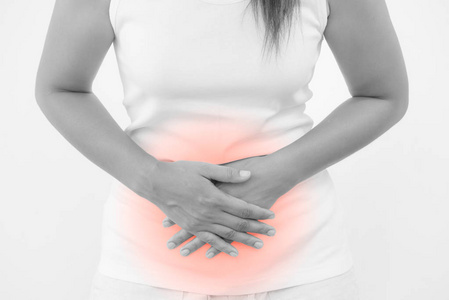 年轻美丽的女人有痛苦的胃痛在白色的背景.慢性胃炎.腹部腹胀概念照片