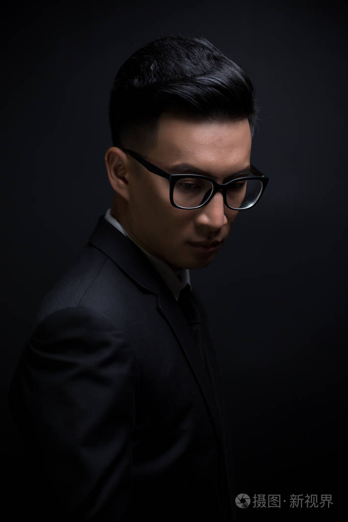 孤立的黑色背景上的黑色西装的商人