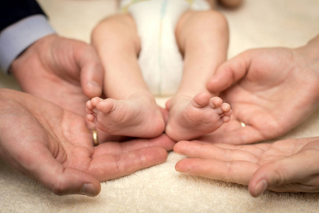 父母的手握着婴儿的脚