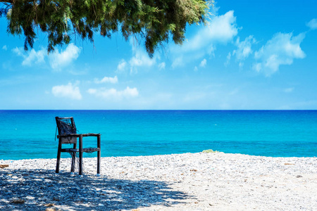 在阳光明媚的日子里, 在克里特岛的海洋海滩和椅子上
