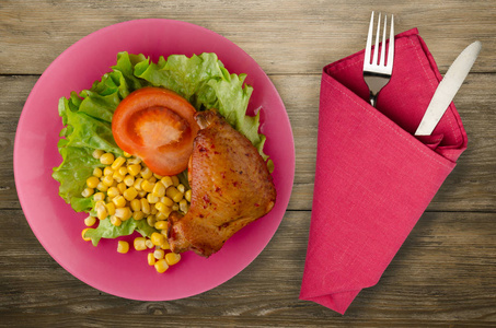 鸡肉翅配沙拉, 玉米和西红柿放在盘子里。田园背景的蔬菜鸡翅