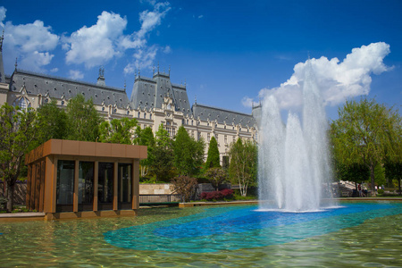 在罗马尼亚雅西市文化宫的喷泉。绿色公园和蓝天背景