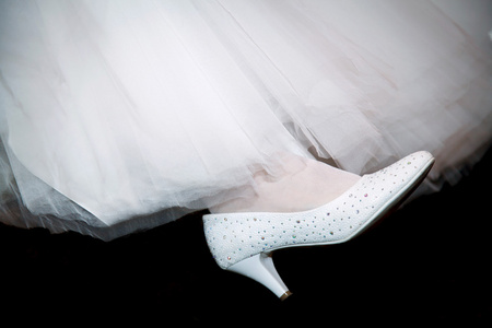 白色的新娘在她腿上的鞋子