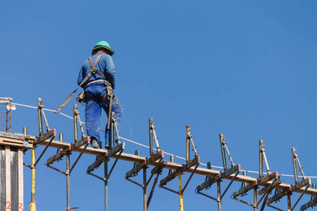 梁一天建筑工人在工地上,在晴朗的一天照片