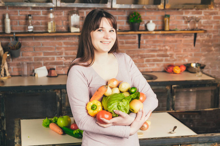 幸福的年轻女人的画像持有的新鲜有机蔬菜