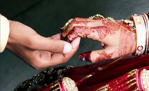在传统的印度婚礼上, 新郎新娘的手紧紧握在一起