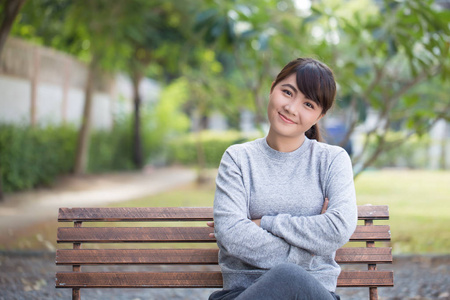幸福的女人坐在公园的板凳上