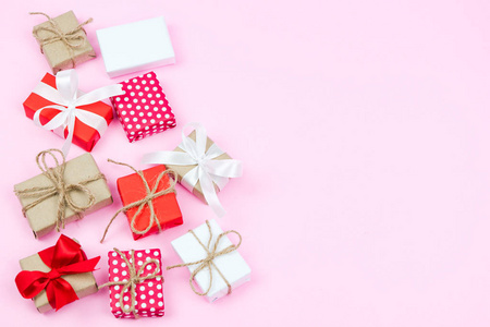 一套在粉红色背景上的各种礼品盒在平躺和顶级视图的圣诞节和新年背景。婚礼请柬, 母亲节贺卡。美丽的生日请柬