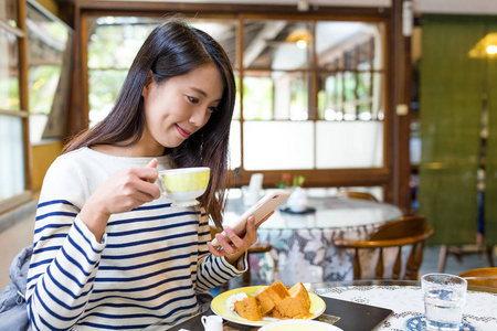 女人享受在咖啡馆的咖啡