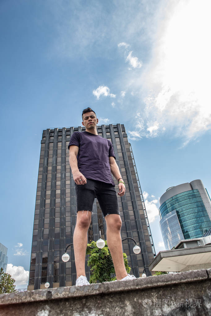 高大的休闲年轻人在城市与办公楼