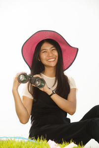 漂亮的亚洲年轻女人在寻找望远镜。
