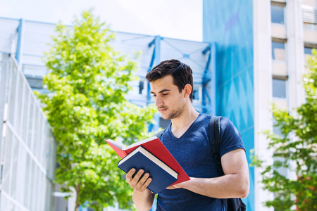 University.Smiling 年轻学生手持男子，在校园里读书