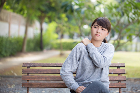 女人在公园有肩痛