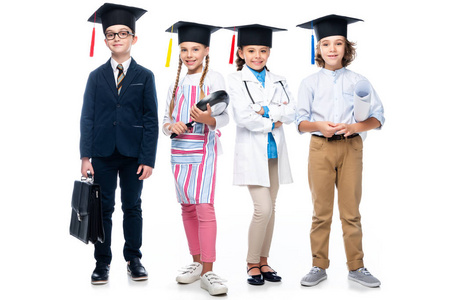 学生在不同的职业服装和毕业帽看着相机在白色隔离
