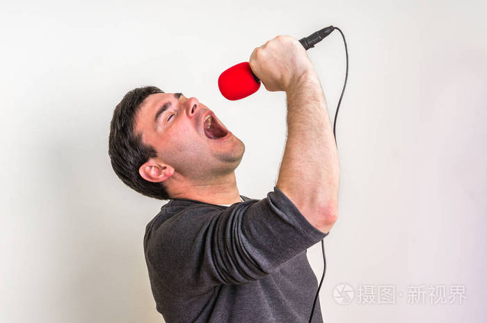 年轻人用红色麦克风唱歌