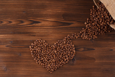 刻字咖啡。咖啡豆在形式的心咖啡，木制的背景下，我爱喝咖啡