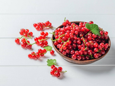 新鲜采摘的红浆果浆果在一个简陋的桌子上的粘土碗。健康天然食品的概念
