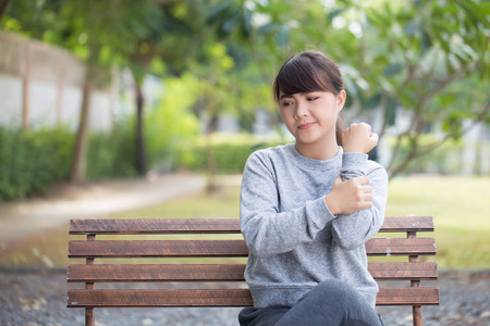 女人在公园有手的疼痛