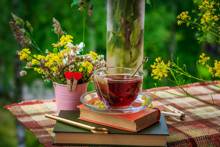 一杯茶和野花在粉红色的铁桶里