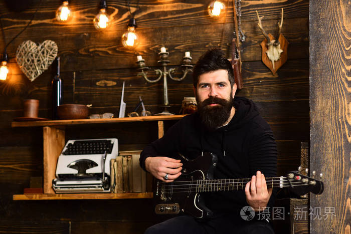 男子胡子音乐家享受晚上低音吉他木质背景灵魂音乐有胡子的人拿着黑色