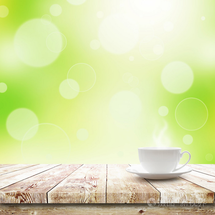 喝些热饮料绿色散景和阳光的桌子上的杯子