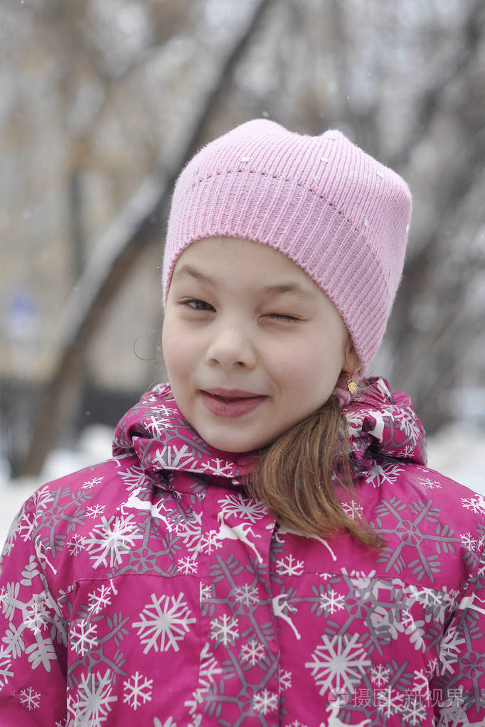 在冬天的衣服快乐的眨眼女孩的肖像