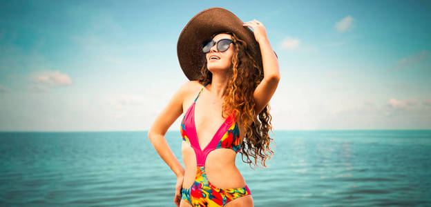 夏天在热带沙滩度假胜地穿泳装的快乐年轻女子度假旅行