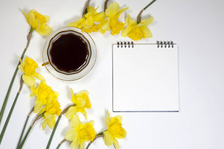 杯咖啡和一碟，在白色背景上的水仙花