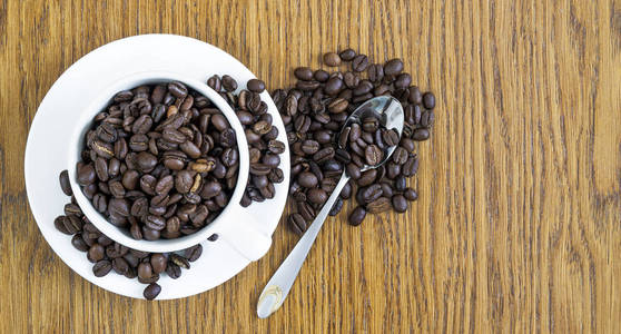在一个白色的杯子和咖啡豆在木桌坝上杯咖啡