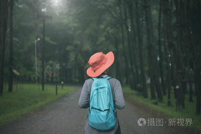自由时髦的旅行妇女站在背包和享受美丽的自然森林