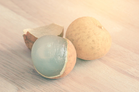 剥肉剥了皮的龙眼果实木制的桌子上照片