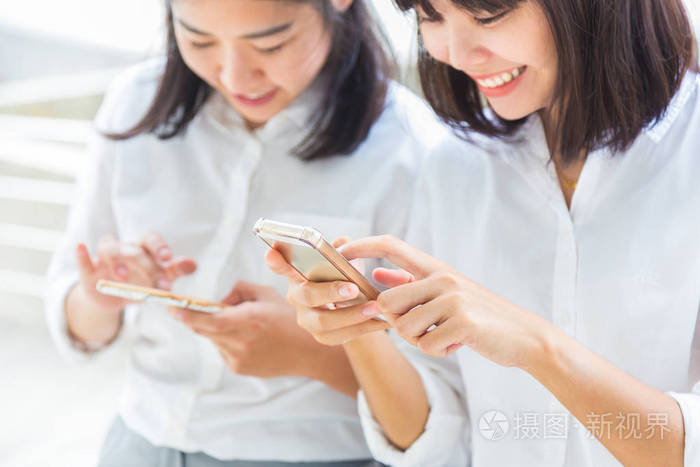 亚洲女性手持并使用智能手机连接
