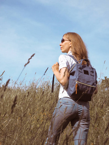 女孩旅行者徒步旅行与背包在高山草甸。旅游生活方式概念冒险暑期户外度假