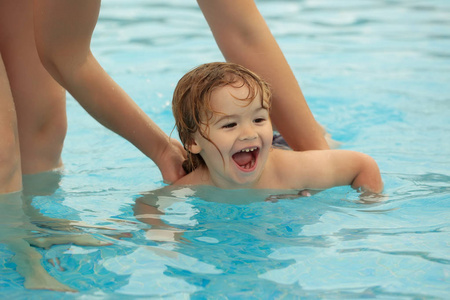 可爱的小宝贝男孩学会了游泳与母亲帮助
