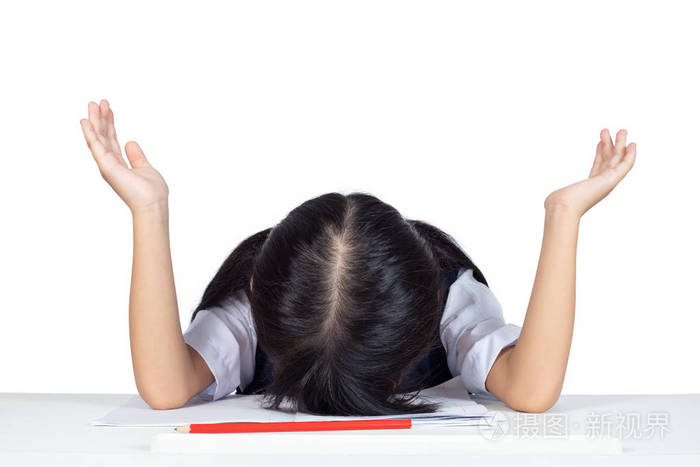 亚洲华人小女孩在学校制服睡在桌子上孤立的白色背景