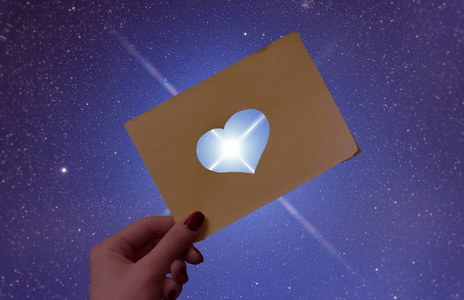 一个人的夜空女孩抱着一个心形的夜空背景照片