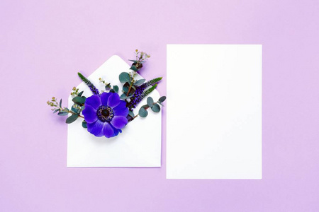 在信封和白色紫罗兰色背景上表中的多彩春天的花朵